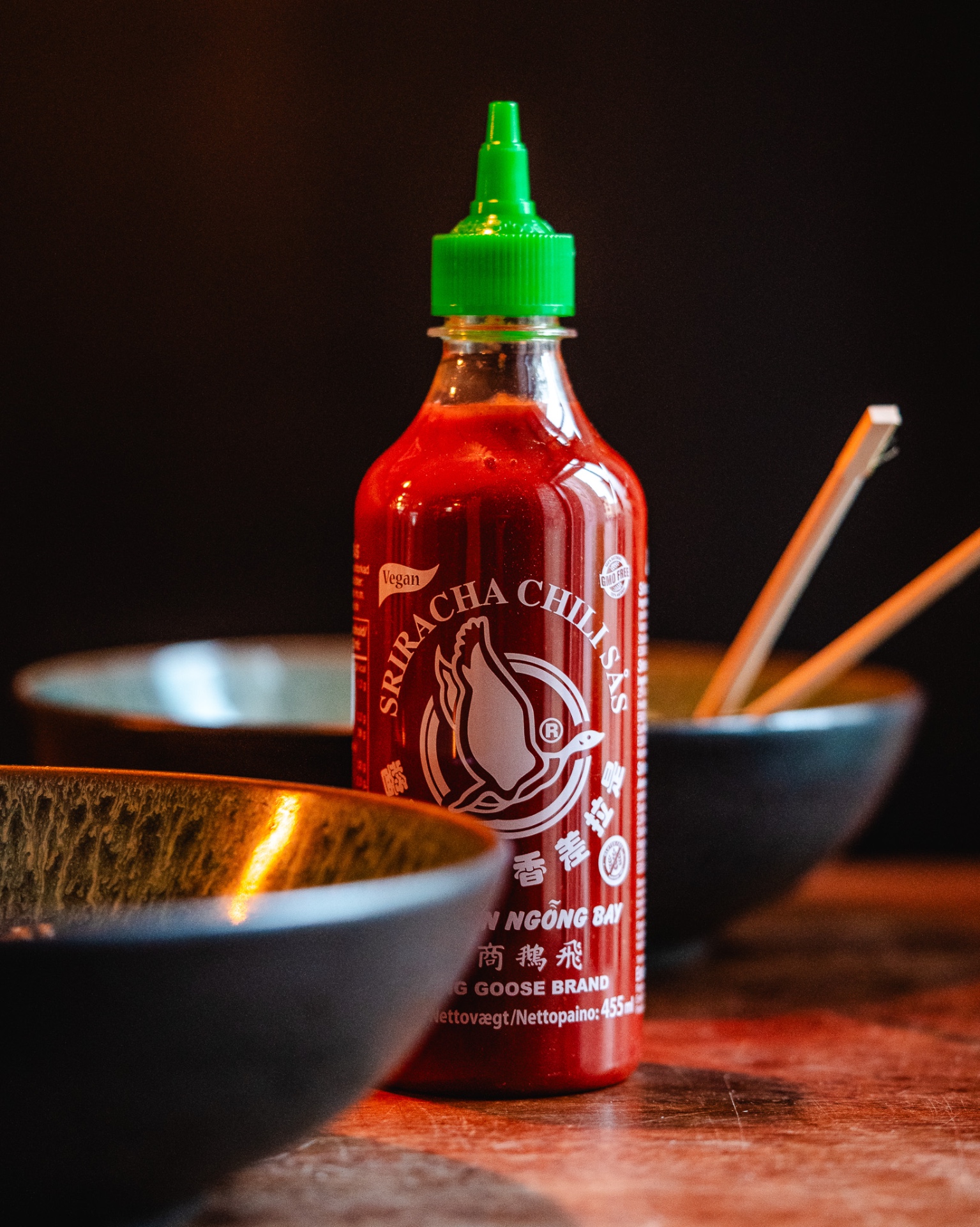 Sriracha chili-sås ved siden af serveringsskåle