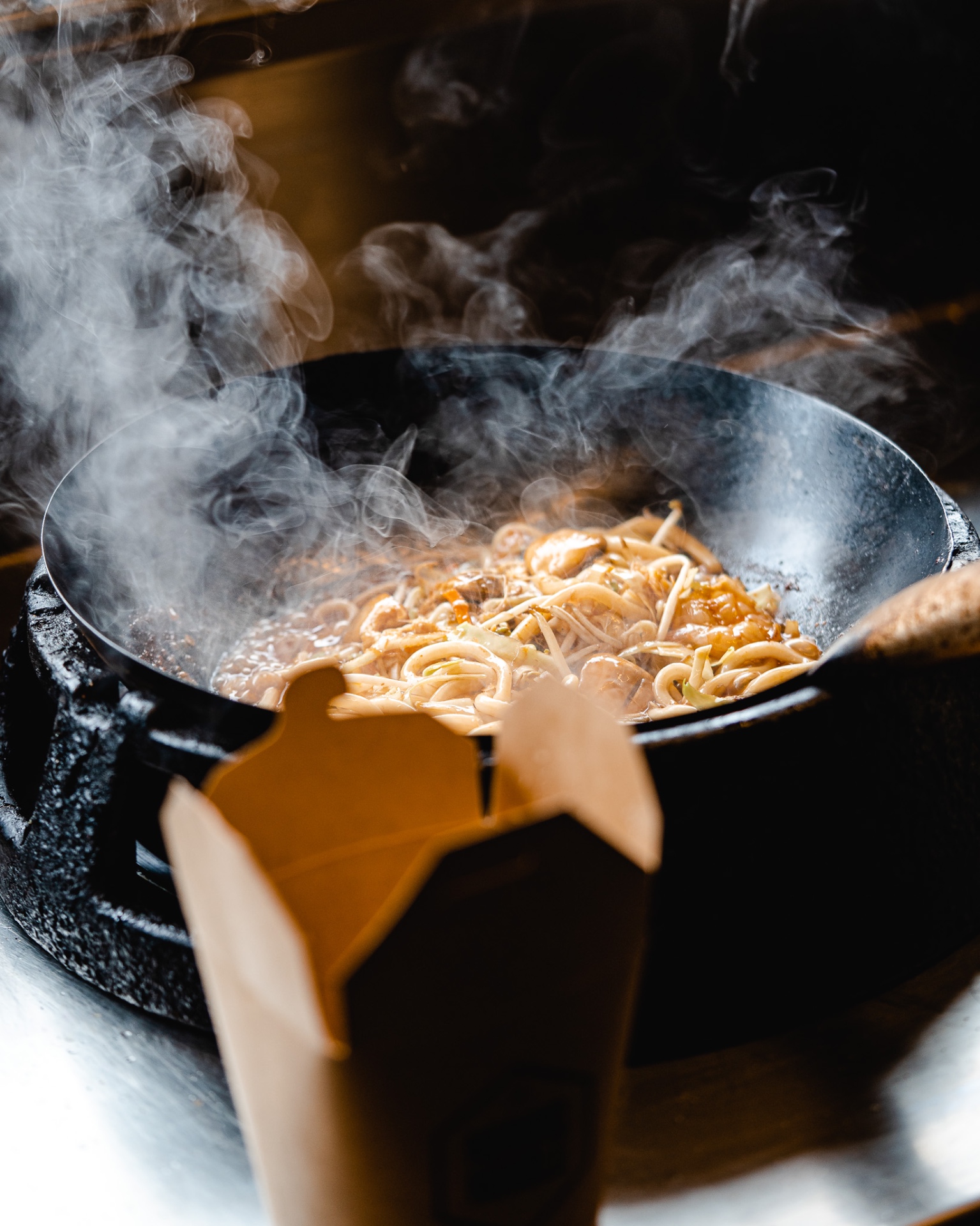 Wok med dampende nudler og takeaway-boks